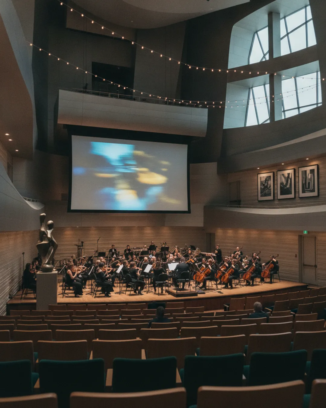 orchestra performing, movie screen, concert hall interior